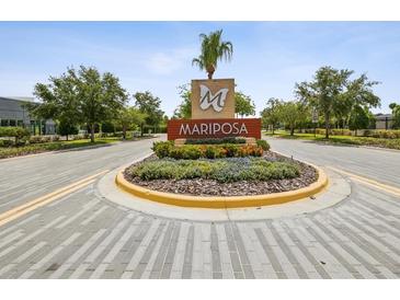 A welcoming entrance to Mariposa featuring lush landscaping and an elegant sign at 10669 Cardera Dr, Riverview, FL 33578