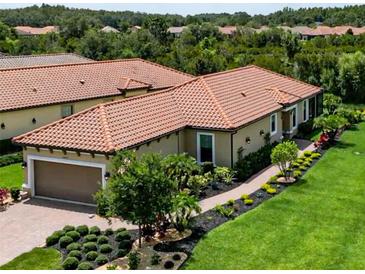 Charming home featuring a clay tile roof, manicured lawn and elegant landscaping at 20025 Callisto Hill Pl, Tampa, FL 33647