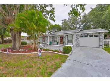 Charming single-story home features brick facade, well-manicured lawn, and a welcoming front porch at 215 Claire Dr, Seffner, FL 33584