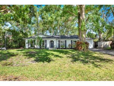 Charming single-story home featuring a well-manicured lawn, mature trees, and classic architectural design at 3615 Greatwood Ct, Land O Lakes, FL 34639