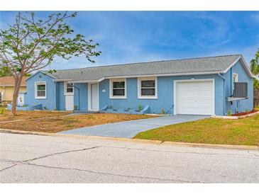 Charming blue single-Gathering home with a well-maintained front yard and an attached single car garage at 410 Virginia Ave, Madeira Beach, FL 33708