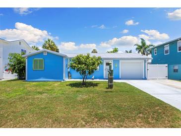 Charming turquoise home with a well-manicured lawn and lovely curb appeal, perfect for coastal living at 4492 Kingston Dr, Hernando Beach, FL 34607