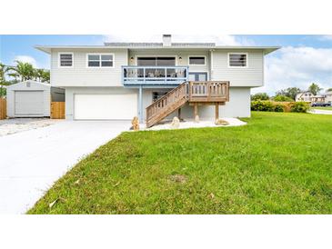 Charming home featuring a well-maintained lawn, garage, and staircase leading to a deck at 4916 Palmetto Point Dr, Palmetto, FL 34221