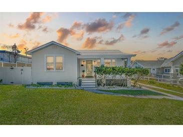 Charming single-story home featuring a well-manicured lawn and a welcoming front porch with meticulously kept shrubs at 106 W Minnehaha St, Tampa, FL 33604