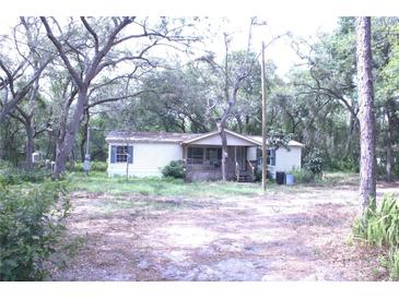 Exterior of a home with mature trees and a partially covered front porch at 10641 Atlee St, New Port Richey, FL 34654