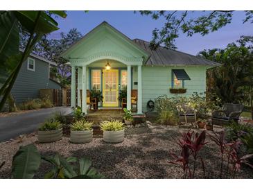 Charming home featuring a cheerful yellow door, complemented by rocking chairs on the welcoming front porch at 111 29Th W St, Bradenton, FL 34205