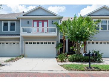 Charming townhome with a two-car garage, lovely landscaping, and a cute second-floor balcony at 2876 Bayshore Trails Dr, Tampa, FL 33611