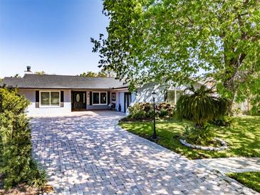 Charming single story home with brick driveway and lush front yard landscaping at 5509 Bluejay Ln, Tampa, FL 33625