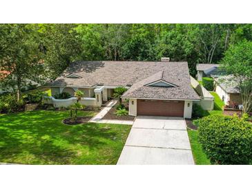 Charming single-Gathering home with a well-manicured lawn, mature trees, and a two-car garage at 6011 Pratt St, Tampa, FL 33647
