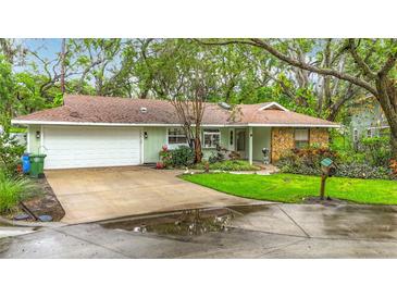 Charming single-story home with a well-manicured lawn and mature trees, creating a welcoming curb appeal at 6901 Arbor Oaks Ct, Bradenton, FL 34209