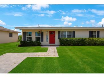 Charming single story home with a bright red door and lush green lawn at 8339 75Th Ave, Seminole, FL 33777