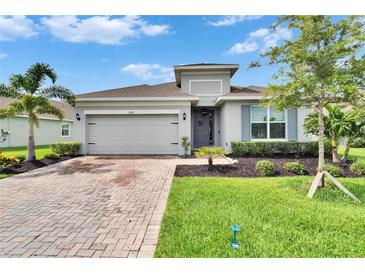 Charming one-story home featuring a brick driveway and a lush, landscaped front yard at 11785 Little River Way, Parrish, FL 34219