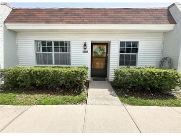 Charming home features a well maintained lawn and beautiful front door with decorative wreath at 13926 Mission Oaks Blvd, Seminole, FL 33776