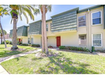 Inviting exterior showcasing palm trees, green lawn, and unique architectural details at 1799 N Highland Ave # 185, Clearwater, FL 33755