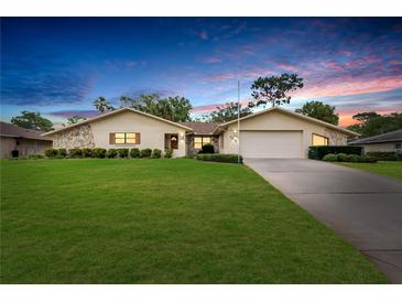 Charming single-story home with stone accents, well-manicured lawn, and an attached two-car garage at 5078 Florentine Ct, Spring Hill, FL 34608