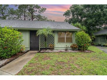 Charming single-story home with a well-maintained lawn, lush landscaping, and security door at 5084 Barrington Cir # 3202, Sarasota, FL 34234