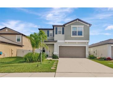 Charming two-story home with a well-manicured lawn and attached two-car garage at 5432 Rainwood Meadows Dr, Apollo Beach, FL 33572