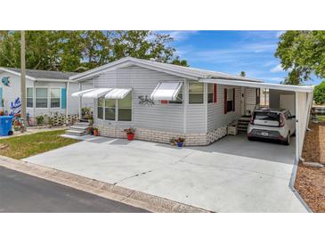 Charming single-story home with a carport, awning-covered windows, and a well-maintained yard at 106 N Saint George Cir, Apollo Beach, FL 33572