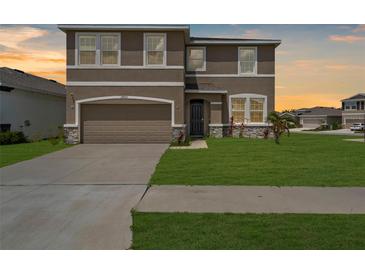 Charming two-story home featuring a well-maintained lawn and a two-car garage at 17005 Avon Dive Ln, Wimauma, FL 33598
