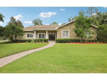 Charming home with a stone facade, manicured lawn, and a brick walkway leading to the front entrance at 1803 143Rd E Ct, Bradenton, FL 34212