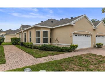 Charming single-story home with a brick walkway, manicured landscaping, and an attached two-car garage at 2616 Tottenham Dr, New Port Richey, FL 34655