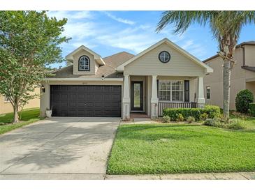 Charming single-story home showcasing a well-maintained lawn, a two-car garage and a welcoming front porch at 30753 Pumpkin Ridge Dr, Wesley Chapel, FL 33543