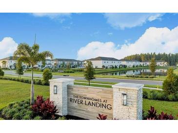 Scenic view of The Townhomes at River Landing entrance with lush landscaping and view of the townhome community at 34234 Polacca Ln, Wesley Chapel, FL 33543
