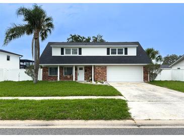 Charming two-story home with a well-manicured lawn, brick facade, and a convenient two-car garage at 4725 Soapstone Dr, Tampa, FL 33615