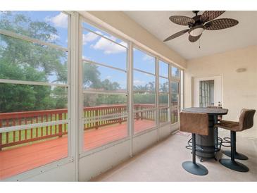 Relaxing screened porch with ceiling fan, outdoor views, and a high-top table for enjoying coffee or cocktails at 6330 99Th N Way # 14B, Seminole, FL 33708