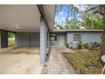 Charming single-story home with a covered carport, brick walkway and tidy landscaping at 12412 Lakeview Dr, Dade City, FL 33525