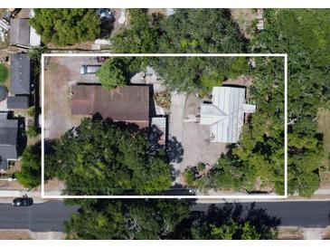 An aerial view of a lot featuring two small homes shaded by mature trees at 14210 Downing St, Dover, FL 33527