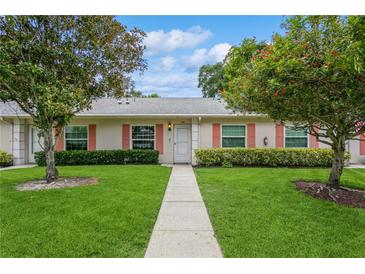 Charming one-story home featuring a well-manicured lawn, colorful shutters, and inviting walkway to the front door at 1535 Nursery Rd # 110, Clearwater, FL 33756
