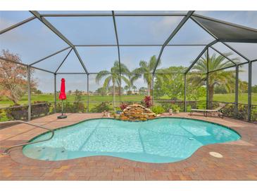 Inviting screened-in pool with waterfall feature and lush landscaping, perfect for relaxation and outdoor enjoyment at 1723 Pacific Dunes Dr, Sun City Center, FL 33573