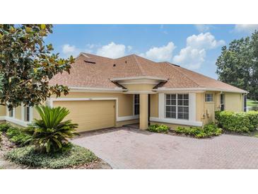 Charming home with a brick driveway, mature landscaping and a two car garage at 27427 Mistflower Dr, Wesley Chapel, FL 33544