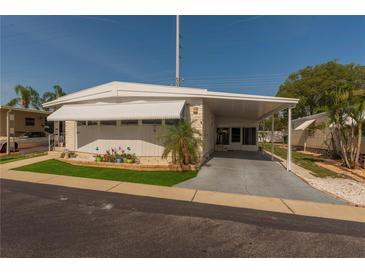 Charming single-story home featuring a carport, awnings, and well-maintained landscaping at 3301 Alt 19 # 819, Palm Harbor, FL 34683