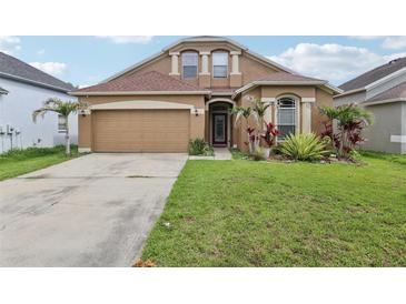 Charming home exterior with well-maintained landscaping and an attached two-car garage at 34447 Windknob Ct, Wesley Chapel, FL 33545