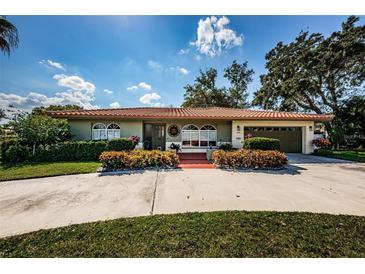 Charming home with a red tile roof, lush landscaping, and a well-maintained front yard at 431 Windward Psge, Clearwater Beach, FL 33767