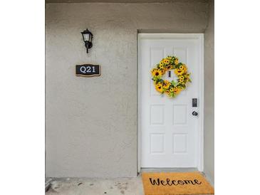 Charming white front door adorned with a sunflower wreath and a welcoming doormat at 4513 S Oak Dr # Q21, Tampa, FL 33611