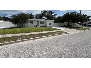 Charming single-story home with a well-manicured lawn and a lovely blue front door at 7536 38Th N Ave, St Petersburg, FL 33710