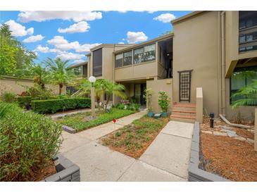 Inviting townhouse exterior with mature landscaping, walkway, and steps to the front door at 1111 N Bayshore Blvd # E10, Clearwater, FL 33759