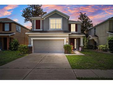 Two-story home featuring a two-car garage, well-maintained lawn, and lovely curb appeal at 13722 Lakemont Dr, Hudson, FL 34669