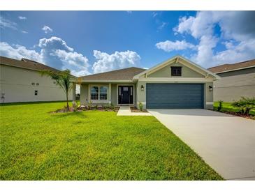 Charming single-story home featuring a manicured lawn and a two-car garage at 16433 66Th E Ln, Parrish, FL 34219