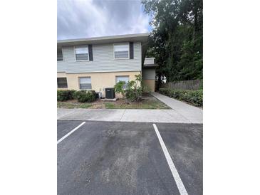 Two-story apartment building with light blue siding and beige accents, surrounded by green bushes and a concrete walkway at 226 Thorn Tree Pl # 226, Brandon, FL 33510