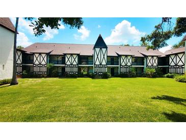 Charming Tudor-style condo building with well-maintained lawn and intricate black and white facade details at 230 N Bayshore Blvd # 103, Clearwater, FL 33759