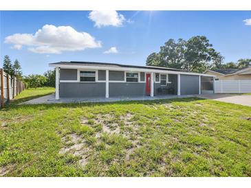 Charming single-story home with a well-maintained lawn and a striking red front door at 2419 Wishing Well Way, Tampa, FL 33619
