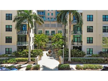 Beautiful condo entrance with tropical palm trees and a water feature surrounded by manicured landscaping at 400 4Th S Ave # 301, St Petersburg, FL 33701