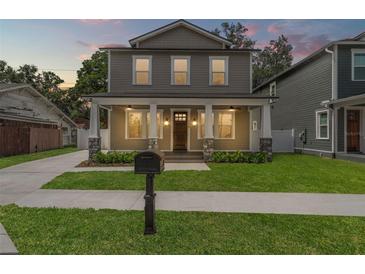Charming two-story home featuring a welcoming front porch with stylish stone accents at 406 E Selma Ave, Tampa, FL 33603