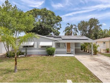 Charming single-story home featuring solar panels, awning-covered windows, and a convenient covered carport at 6497 43Rd N Ave, Kenneth City, FL 33709