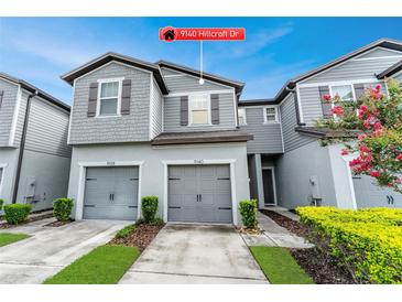 Charming gray two-story home with attached two-car garage and landscaped yard at 9140 Hillcroft Dr, Riverview, FL 33578