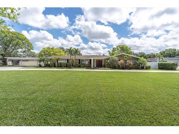 Charming single-story home featuring a huge front lawn, mature trees and attractive landscaping at 10611 131St St, Largo, FL 33774